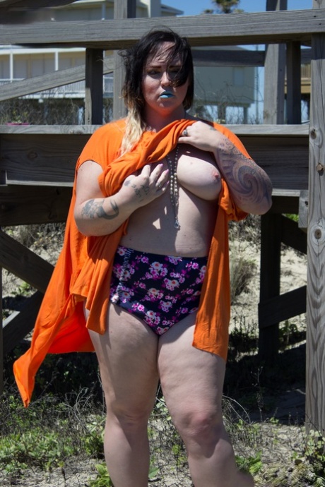 Chubby shemale Michelle Austin shows her big tits and her small dick outdoors