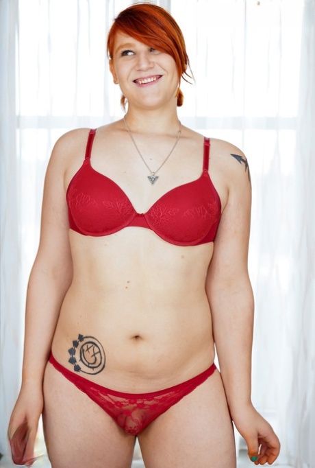Redheaded shemale fatty Ashlee Alespia strips & shows her big ass & tiny dick