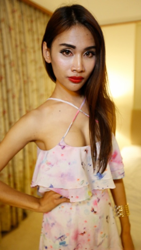Pretty Asian shemale shows her lovely tits while teasing in a sexy outfit